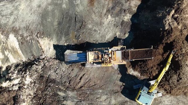 Top Down Aerial View of Excavator Loading Industrial Mulch Grinder