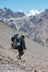 A lone climber climbs a slope in the snowy mountains in winter. Photographer in the mountains