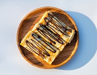 Stacked, folded crepes drizzled with chocolate, on a wooden plate