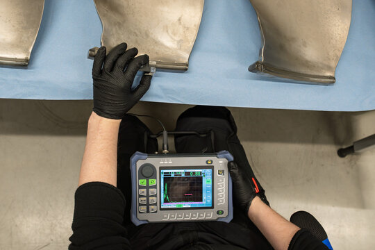 Aviation Technician Inspecting Aircraft Turbine Fan Blade Using Ultrasonic Testing Equipment. Professional Non-Destructive Inspection Method for Detecting Cracks and Flaws in Engine Components