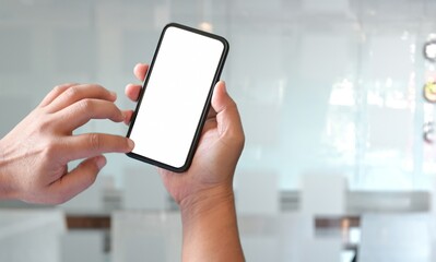 Person holding a smartphone with a blank screen in a modern brightly lit environment