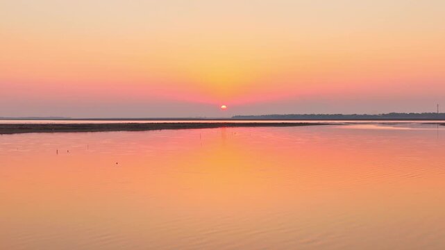 At sunset, flocks of migratory birds, swans, and geese take flight over Poyang Lake.
