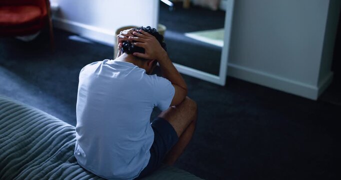 Mental health, back and man in bedroom with stress, anxiety trigger or memory of past mistake. Grief, flashback and male person in house with sadness, loss or frustrated in emotional thoughts.