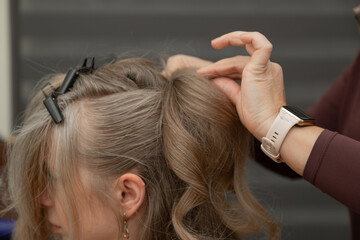 Fototapeta premium CloseUp of Hairstylist Hands Sectioning Hair for Child Hairstyle