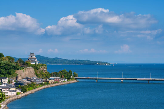 Kitsuki castle on cliff by city and bridge cross turquoise sea, Oita