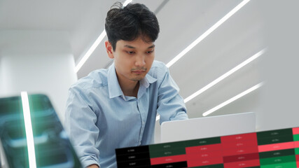 Professional trader watching real-time financial statistics and candlestick graphs on a computer screen for investment decision making