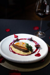 A culinary delight. An elegantly plated dish, showcasing an exquisite main course. The setting evokes a sense of romance and indulgence