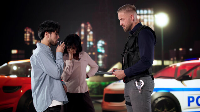 Driver Taking Breathalyzer Test As Passenger Watches With Concern