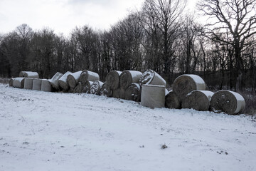 A pile of rolled hay on a snowy field