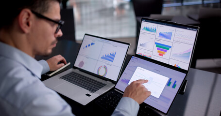 Young Latino Consultant Using Laptop To Analyze Business Data