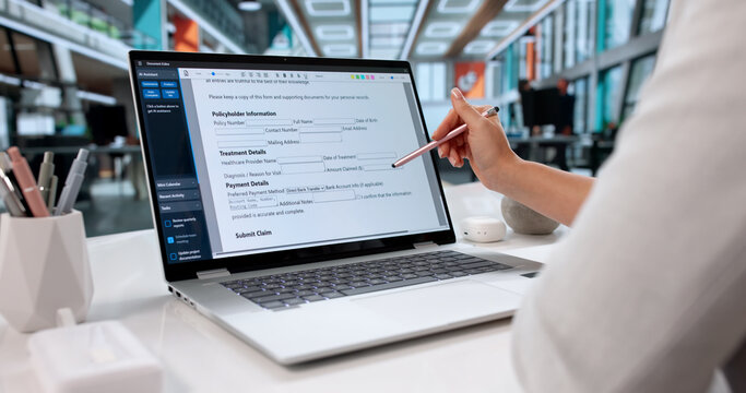Woman Filling Out Health Insurance Claim Form On Laptop Computer
