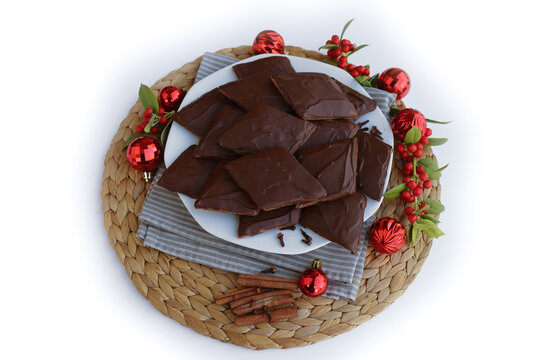 Italian traditional festive cookies called Mostaccioli or Mustaccioli on a plate on white with copy space. Christmas cookies made mith Pisto, a mix of various spices