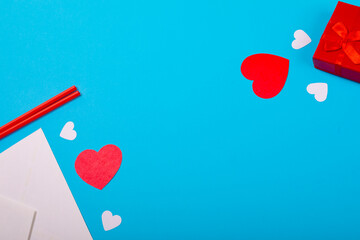 Overhead view of red heart shapes with envelope and gift box by copy space