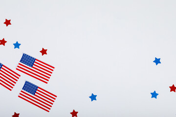 Overhead view of usa flags by scattered star glitters with copy space on white background