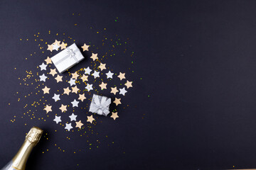 Valentine gift boxes on stars arranged as heart shape by champagne bottle by copy space