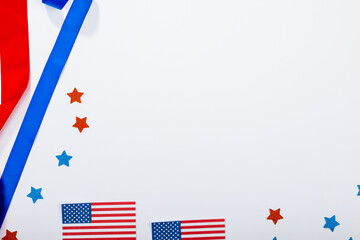 Overhead view of usa flag with star shape confetti and ribbon by copy space on white background