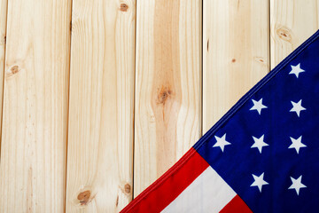 Stars with red and white stripes on america flag flattened over wooden table with copy space