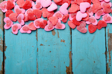 Overhead view of heart shaped pink candies on wooden table, copy space
