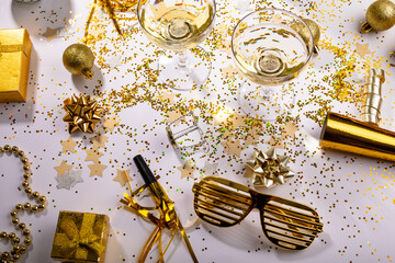 Champagne glasses with gold colored decoration and gift boxes on table, copy space