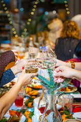 Close-up of hands with champagne glasses at festive table