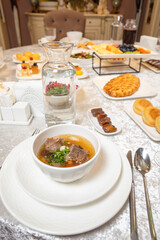 Top view of set table with soup bread and desserts in elegant presentation