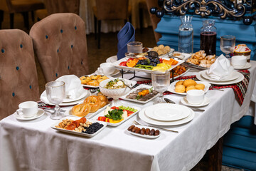 Top view of table with assorted dishes fruits and drinks in luxurious interior
