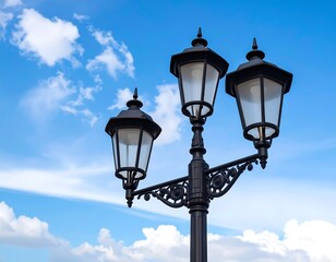 Ornate black lamppost with three lights against a bright blue sky filled with fluffy white clouds, evoking a classic scene