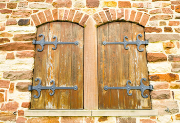 Rustic wooden windows with fittings on an old ruin.
