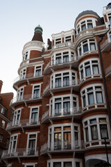 Obraz premium Stroll along Hans Crescent with elegant red brick townhouses and vibrant city life Knightsbrigde in London
