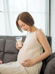 Asian pregnant woman drinking milk for the health of herself and her unborn baby.