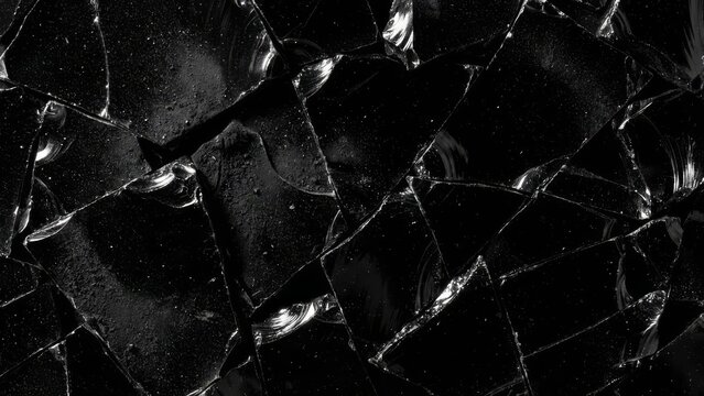 Shattered Glass Fragments on Black Background with Reflective Edges.