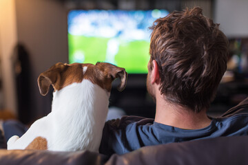 Plakat Man watching tv movie football superbowl with dog puppy doggy viewed from back