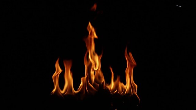 Fire flames burning in the dark night with black background. Abstract flame pattern symbolizing danger, heat, energy, power, passion, and dramatic atmosphere for design and advertising use.