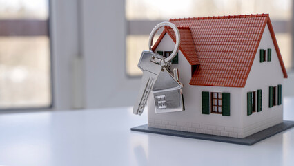 Model of a house with keys to a new house. real estate and rental housing concept