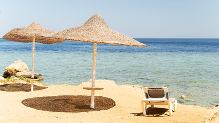 Sun loungers on the beach by the sea at sunset