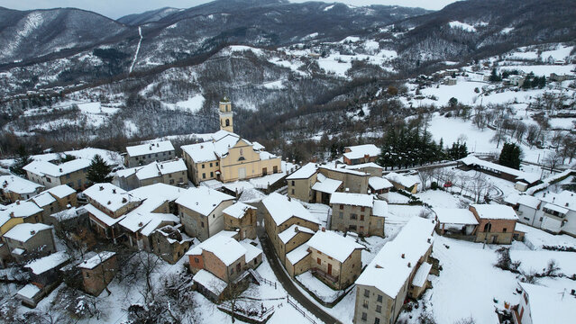 Aerial view of Vezzolacca village in Vernasca, Italy, covered in winter snow