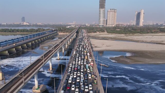 Aerial view of polluted Yamuna River at Kalindi Kunj with heavy traffic in Delhi, India