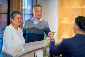 Obraz premium A couple senior traveler checking in for the hotel reservation area to relax for travel in the city.