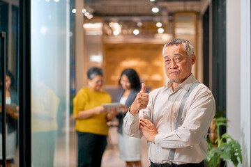 Casual businessman portrait thumb up with working team at co-working space for quality confirm.