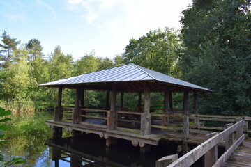 wooden hut build above the water of a lake, Luxembourg in autumn