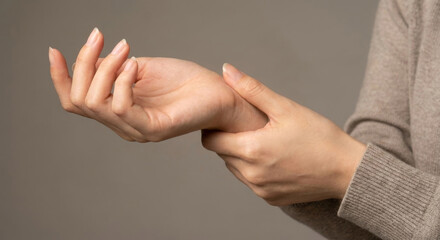 Close up woman massaging her wrist due to pain from carpal tunnel syndrome or office syndrome.