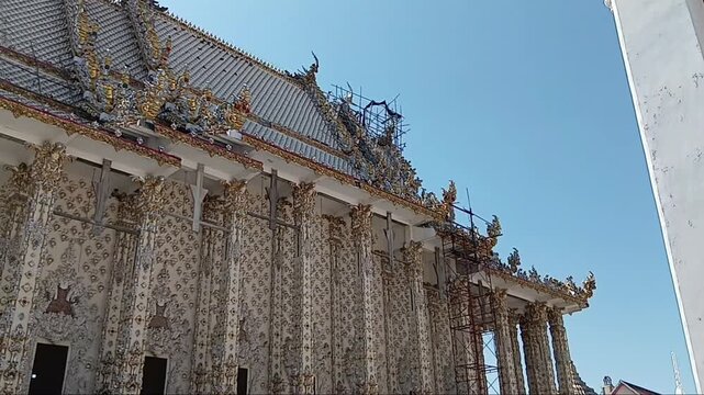 Exterior view of a Thai temple&rsquo;s Ubosot (ordination hall) surrounded by serene grounds. Traditional architecture, cultural details, and peaceful outdoor atmosphere