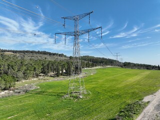 Aerial view of high voltage power lines and electricity pylons over agricultural fields.
Cinematic drone footage showing high voltage electricity pylons and power transmission lines crossing open agri