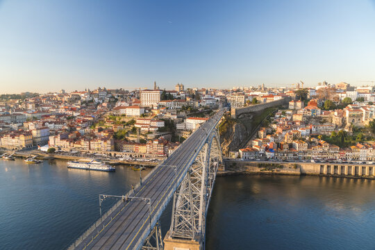 View of the Dom Lu&Atilde;&shy;s I Bridge stretches over the Douro River with the city's terracotta rooftops under a serene sky, Porto, Porto District, Portugal.