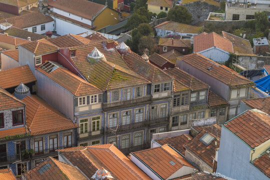 View of warm terracotta rooftops meet aged facades with ornate window frames creating a captivating tapestry of urban history, Porto, Porto District, Portugal.
