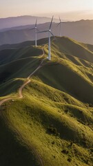 Wind turbines on a rolling grassy mountain ridge during golden hour, symbolizing clean energy and environmental sustainability.