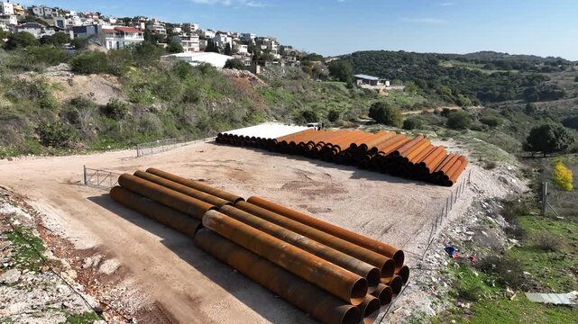 Northern Israel, Israel - January 15 2025: Aerial view of stacked heavy industrial steel pipes
Cinematic drone footage showing a large pile of heavy industrial steel pipes stacked outdoors in an indus