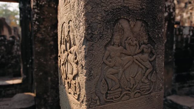Stone pillar with bas relief carvings of traditional apsara dancers at the historic bayon temple in angkor thom, Cambodia. Archeology concept.
