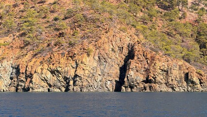 Dramatic Close-Up of Stratified Red-Brown Coastal Cliffs on the Mediterranean Sea near Adrasan, Turkey.