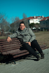 Fototapeta premium Man relaxing on park bench enjoying leisure time